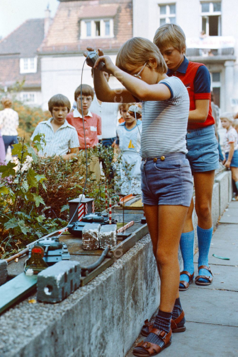 GDR photo archive: Berlin - Boy plays with a toy tank at the Pankefest in East Berlin on the territory of the former GDR, German Democratic Republic