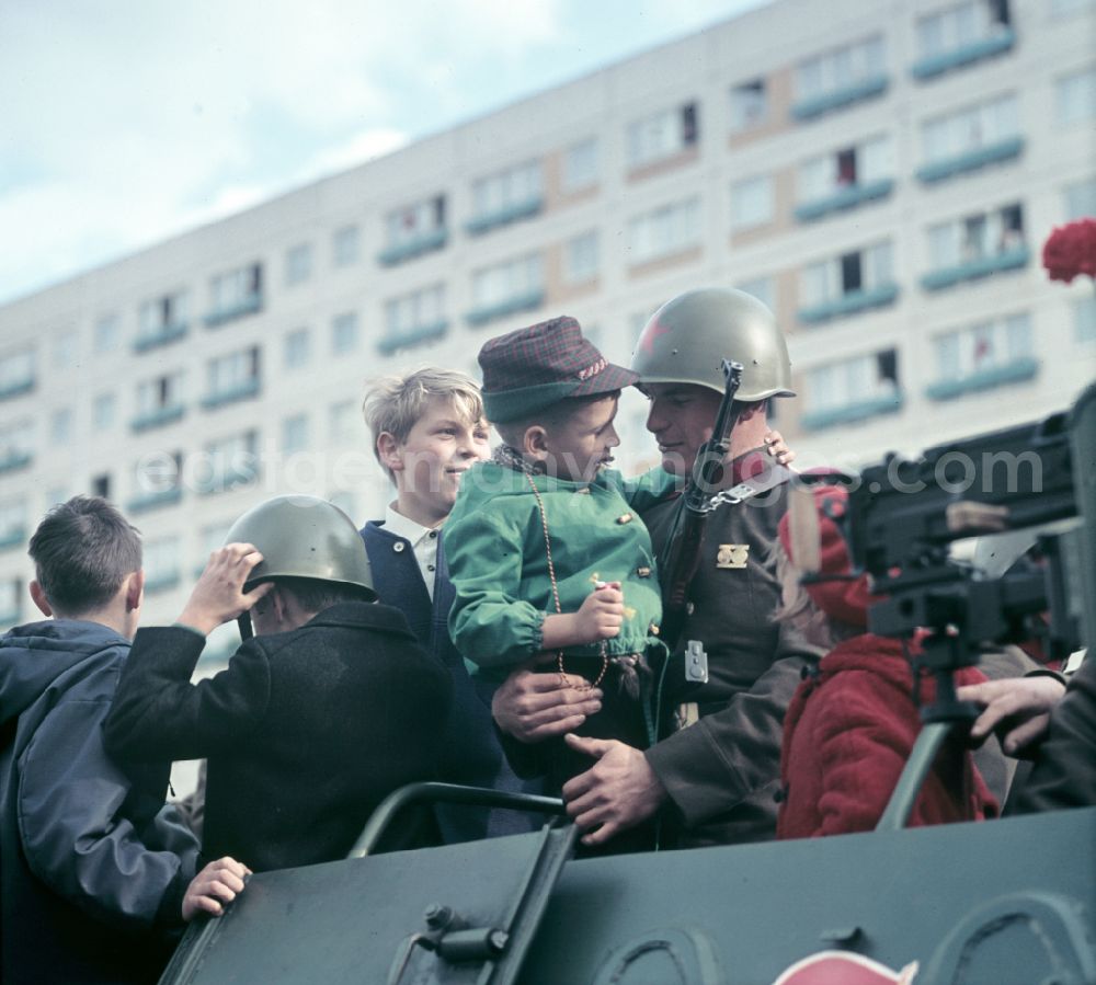 GDR image archive: Berlin - Enthusiastic population forming a guard of honor for the parade drive of military and combat technology Armored infantry vehicle SPW BRDM-1 on Lichtenberger Strasse in the district of Friedrichshain in East Berlin in the territory of the former GDR, German Democratic Republic