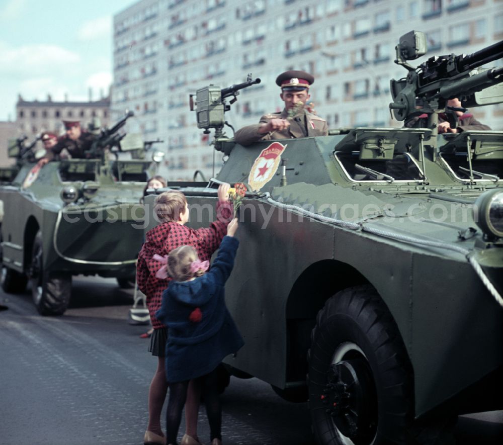 GDR picture archive: Berlin - Enthusiastic population forming a guard of honor for the parade drive of military and combat technology Armored infantry vehicle SPW BRDM-1 on Lichtenberger Strasse in the district of Friedrichshain in East Berlin in the territory of the former GDR, German Democratic Republic