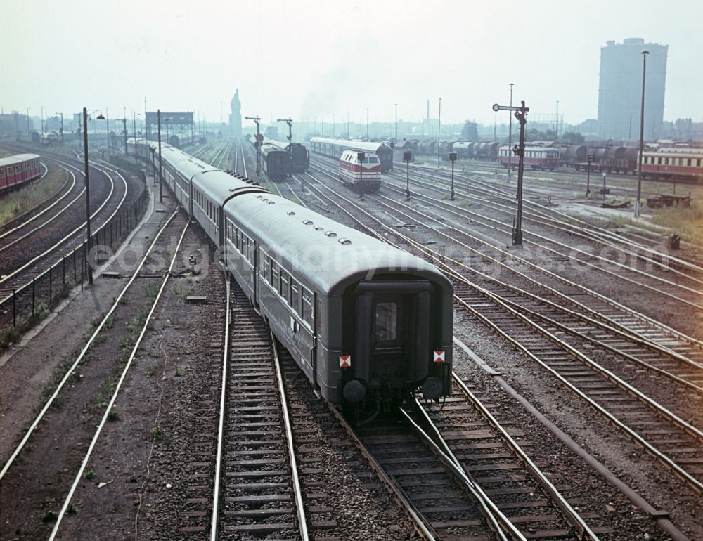 GDR picture archive: Berlin - Passenger train in motion on the tracks of the Deutsche Reichsbahn in East Berlin in the territory of the former GDR, German Democratic Republic