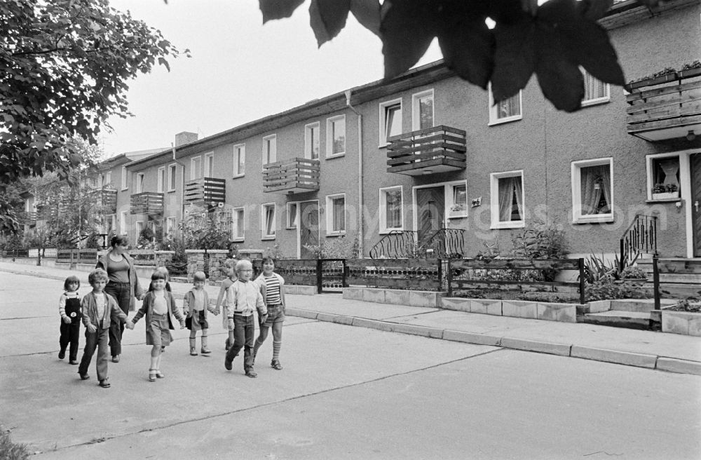 GDR photo archive: Berlin - Group of children with a teacher in the terraced house complex taking a walk on Am Falkenberg in the Gruenau district of Berlin, East Berlin in the territory of the former GDR, German Democratic Republic