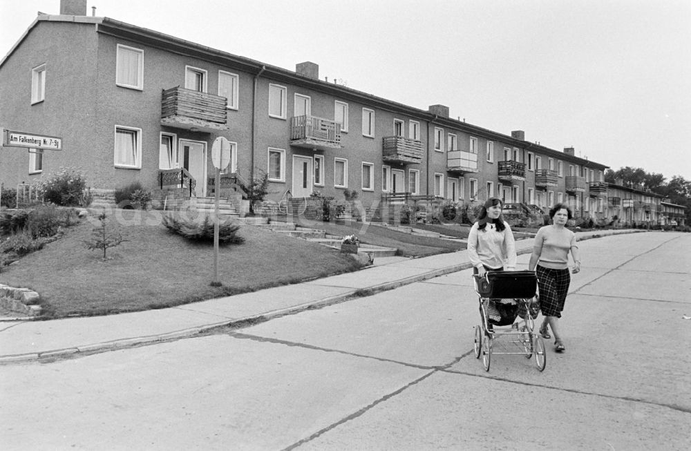 GDR picture archive: Berlin - Mother with stroller accompanied in the terraced house complex on the street Am Falkenberg in the district of Gruenau in the district Gruenau in Berlin East Berlin in the territory of the former GDR, German Democratic Republic