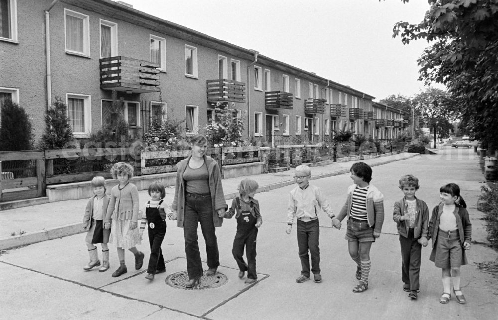 Berlin: Group of children with a teacher in the terraced house complex taking a walk on Am Falkenberg in the Gruenau district of Berlin, East Berlin in the territory of the former GDR, German Democratic Republic