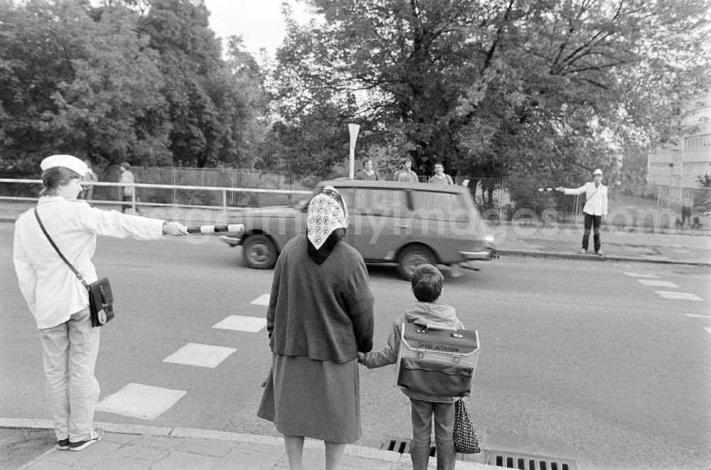 GDR photo archive: Berlin - School crossing guards on the way to school for pedestrians and passers-by in traffic at the intersection at Schulzendorfer Strasse and Waltersdorfer Strasse in the district of Bohnsdorf in Berlin East Berlin in the area of the former GDR, German Democratic Republic