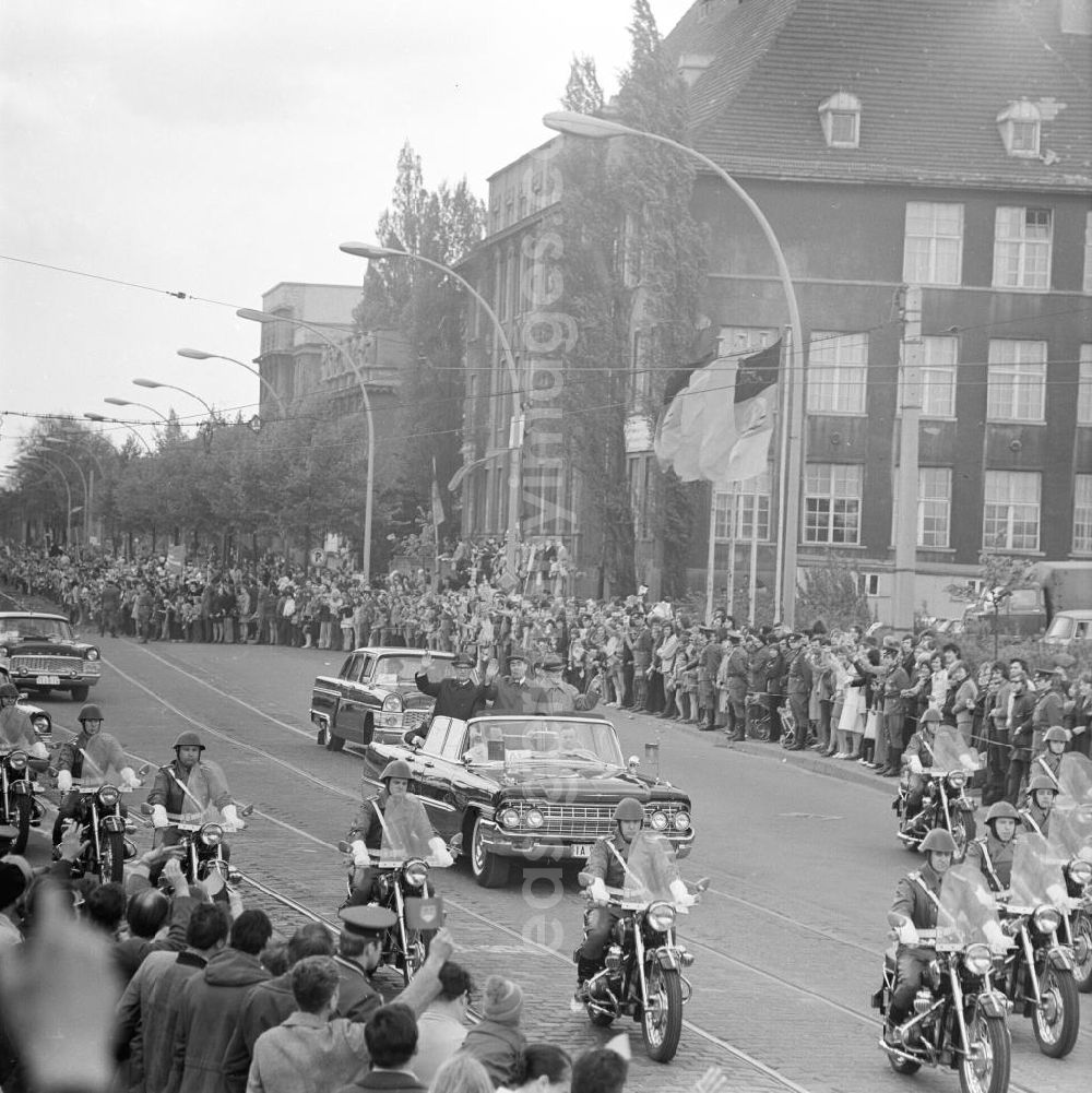 Berlin: Erich Honecker und Besuch aus der Sowjetunion Herr Breschnew winkend im fahrenden Auto, Zuschauer stehen am Straßenrand.