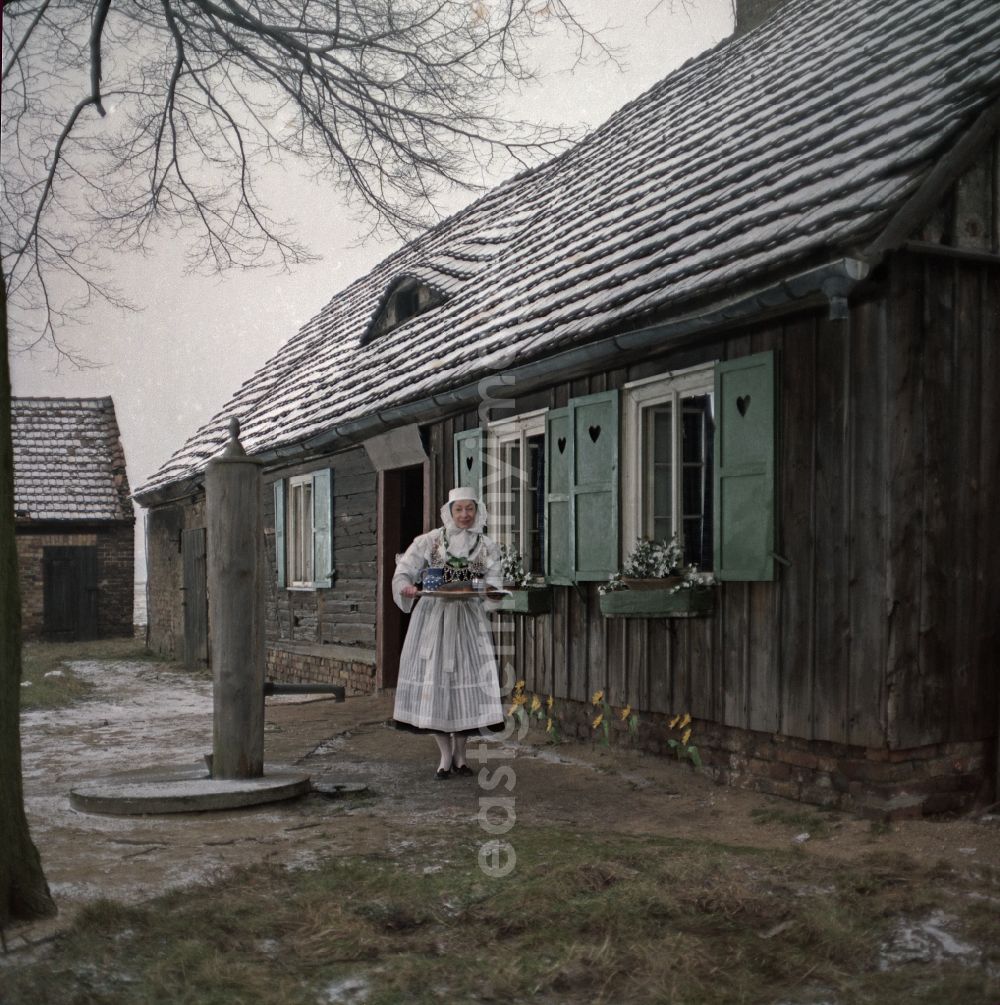 GDR image archive: Kreba-Neudorf - Scene from the film and television production Continent Hope with the actress Majka Kowarjec in Sorbian costume as a mother in front of an old farm in Kreba-Neudorf, Saxony in the area of the former GDR, German Democratic Republic