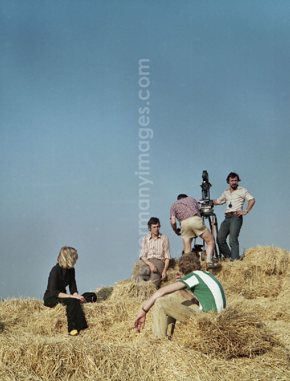 GDR photo archive: Crostwitz - Scene shot from the film and television production Portrait of a Center in Crostwitz, Saxony in the area of the former GDR, German Democratic Republic. The film crew uses stacked straw bales as an elevated vantage point and sets up the camera on a tripod