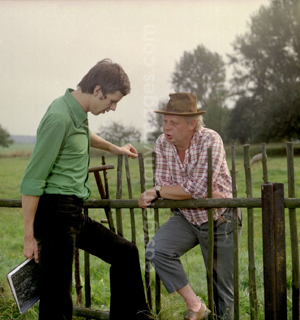 GDR image archive: Horka - Scene from the film and television production Portrait of a Center on the main street in Horka, Saxony in the area of the former GDR, German Democratic Republic. The director Konrad Herrmann in conversation with the Sorbian children's book author Jan Worner