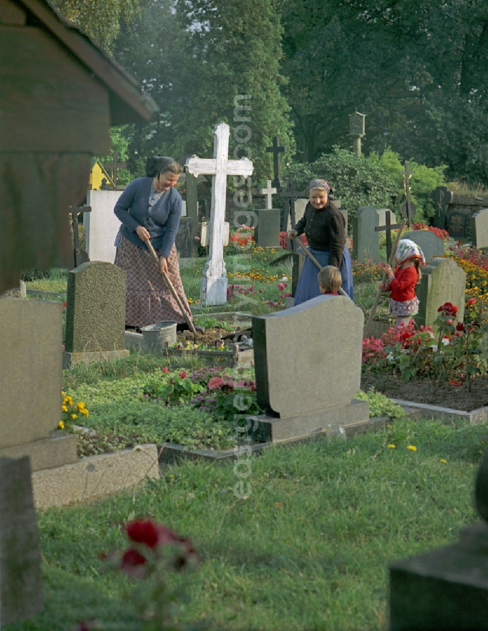 GDR image archive: Ralbitz - Scene from the film and television production Portrait of a Center in front of grave crosses and cemetery stones of a Sorbian cemetery on the main street in Ralbitz, Saxony in the area of the former GDR, German Democratic Republic