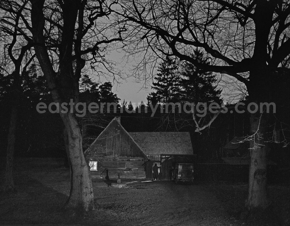 GDR picture archive: Weißkeißel - Scene from the film and television production Rublak - The Legend of the Surveyed Land in the Haide district of Weisskeissel, Saxony in the area of the former GDR, German Democratic Republic. The actor Christian Grashof stands in front of it like a shadow and looks towards the entrance of a farmhouse