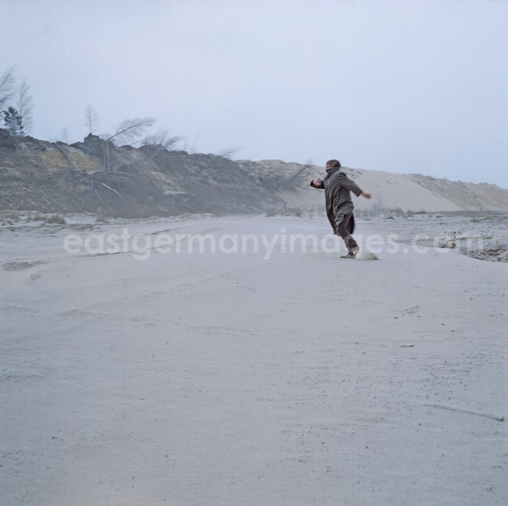 GDR image archive: Weißwasser/Oberlausitz - Scene from the film and television production Rublak - The Legend of the Surveyed Land in Weisswasser/Oberlausitz, Saxony in the area of the former GDR, German Democratic Republic. The actor Christian Grashof dances on a large, flat sandy plain in the waste landscape of a brown coal open-cast mine