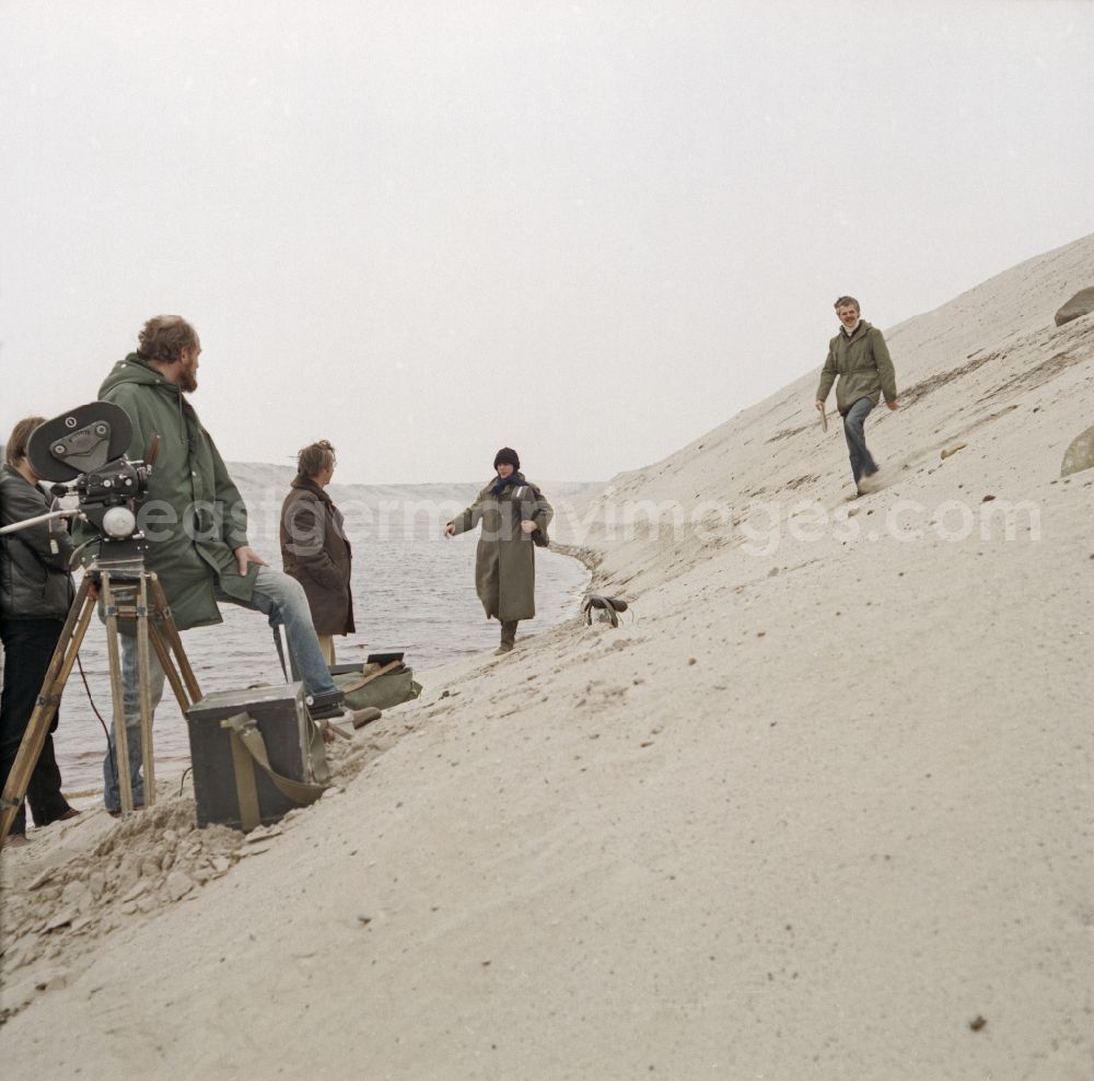 GDR picture archive: Weißwasser/Oberlausitz - Scene from the film and television production Rublak - The Legend of the Surveyed Land in Weisswasser/Oberlausitz, Saxony in the area of the former GDR, German Democratic Republic. The actor Christian Grashof walks with a violin case under his arm through the sandy plain in the waste landscape of a brown coal open-cast mine