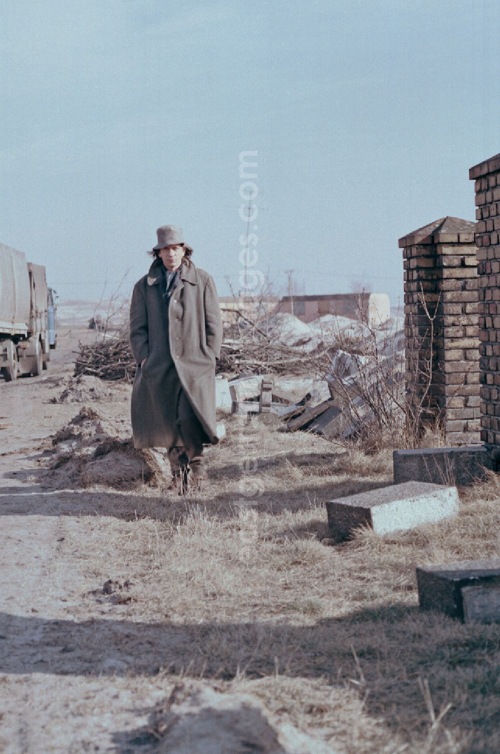 GDR image archive: Spremberg - Scene from the film and television production Rublak - The Legend of the Surveyed Land Waste landscape in Lusatia - the actor Christian Grashof walks past the destroyed entrance of a cleared cemetery entrance on the street Scene in Spremberg in GDR