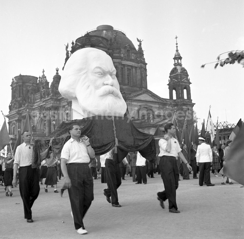 GDR photo archive: Berlin - Participants of the May 1st demonstrations with a larger-than-life bust of Karl Marx on the streets of the city center at Schlossplatz - Marx-Engels-Platz in front of the Berlin Cathedral in the Mitte district of Berlin, East Berlin on the territory of the former GDR, German Democratic Republic