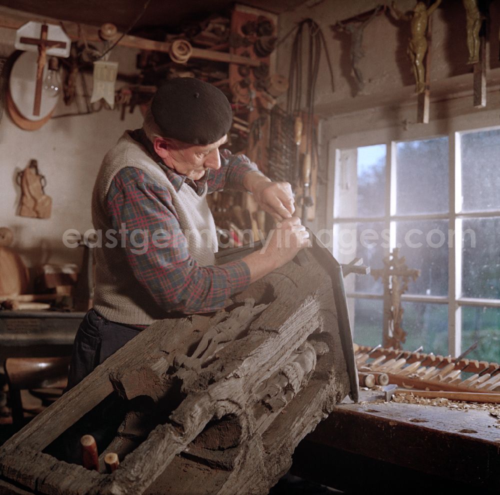 GDR picture archive: Räckelwitz - Scene in the film Portrait of a Center: Staff of a woodworking craft company restoring Sorbian wood carvings in Raeckelwitz, Saxony in the area of the former GDR, German Democratic Republic