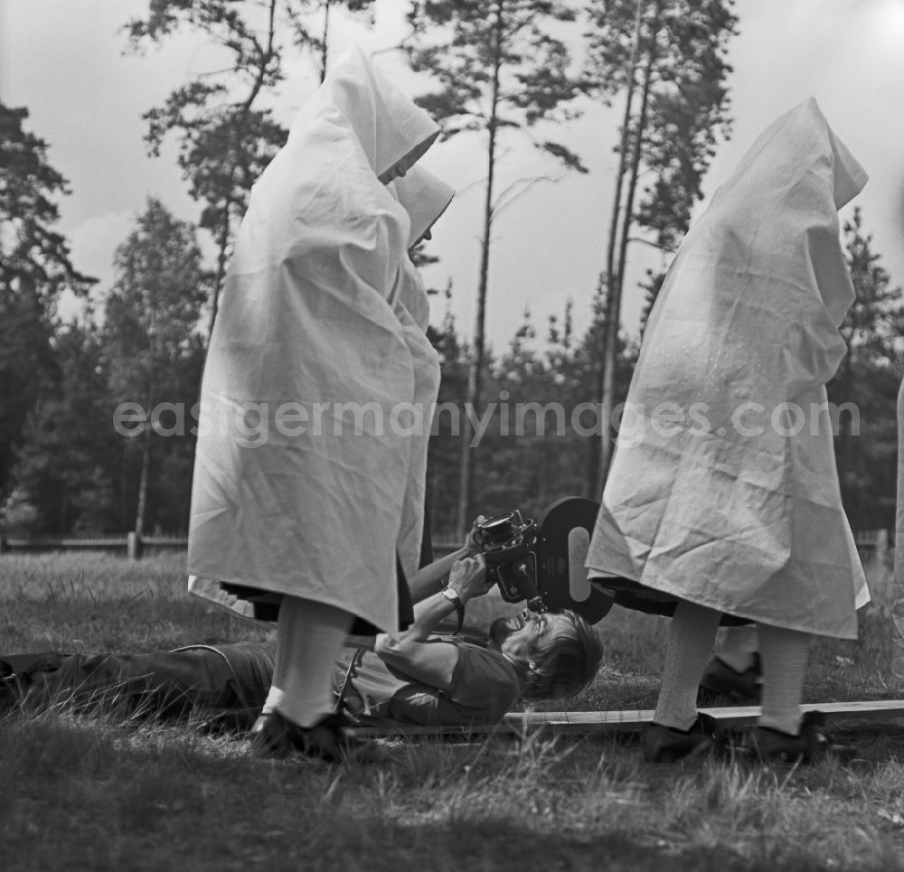 GDR picture archive: Weißwasser/Oberlausitz - Traditional costumes and clothing of a Sorbian farmer's wife as a scene in the film Rublak - The Legend of the Surveyed Land in the town of Heide, Saxony in the area of the former GDR, German Democratic Republic. The cameraman Franz Ritschel lies on the lawn and films