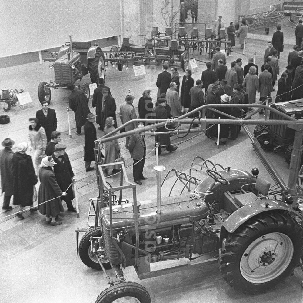 GDR image archive: Leipzig - Besucher der Frühjahrsmesse betrachten verschiedene Exponate, hier Maschinen der Landwirtschaft. In der Halle sind mehrere Traktoren zu sehen. Im Frühjahr und im Herbst eines jeden Jahres war die Leipziger Messe Treffpunkt der internationalen Handelswelt. Bestmögliche Qualität nach Vorlage!