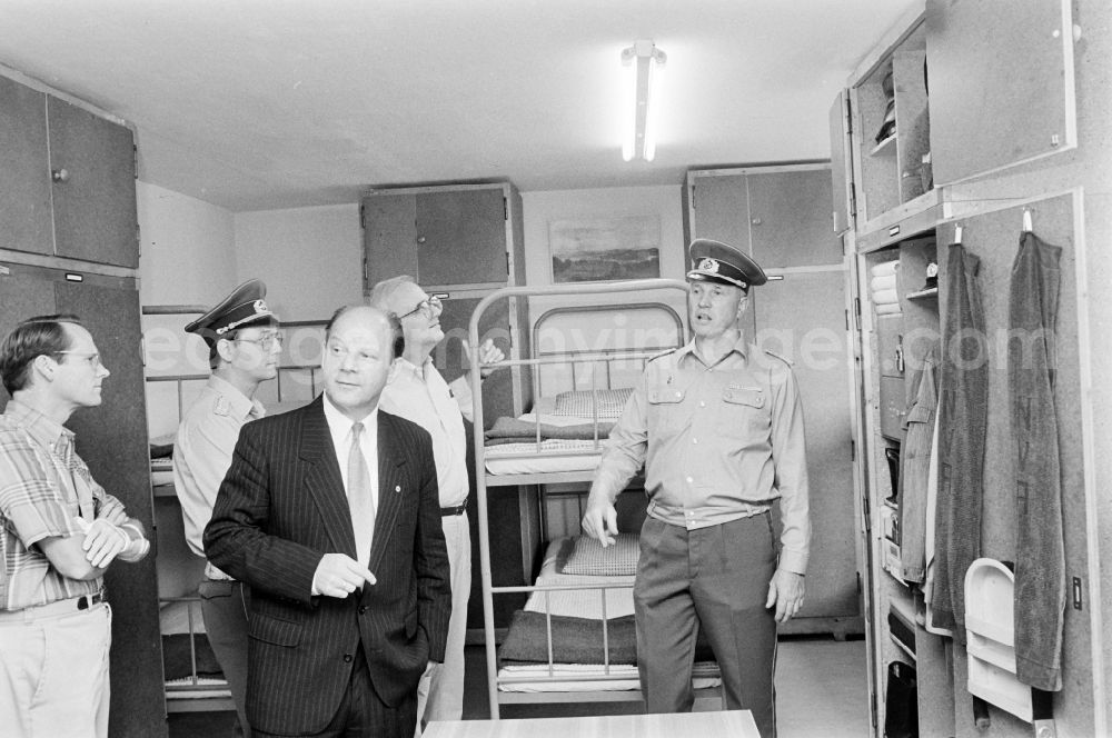 GDR picture archive: Oranienburg - Wolfgang Herger - Head of the Security Affairs Department at the Central Committee of the SED during a visit to a crew quarters during a meeting of army members of the NVA National Peoples Army on the occasion of a troop visit by American soldiers and military observers in the 2nd Konrad Wolf radio regiment in Oranienburg, Brandenburg in the territory of the former GDR, German Democratic Republic