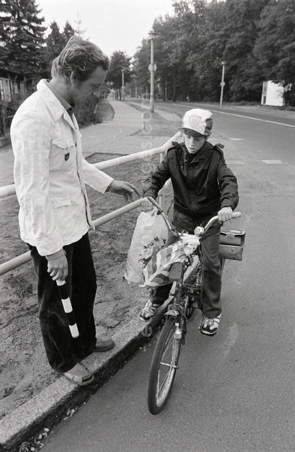 Berlin: Volunteer traffic assistant of the People's Police checking the road safety of a cyclist in traffic at the intersection at Schulzendorfer Strasse and Waltersdorfer Strasse in the Bohnsdorf district of Berlin, East Berlin in the territory of the former GDR, German Democratic Republic