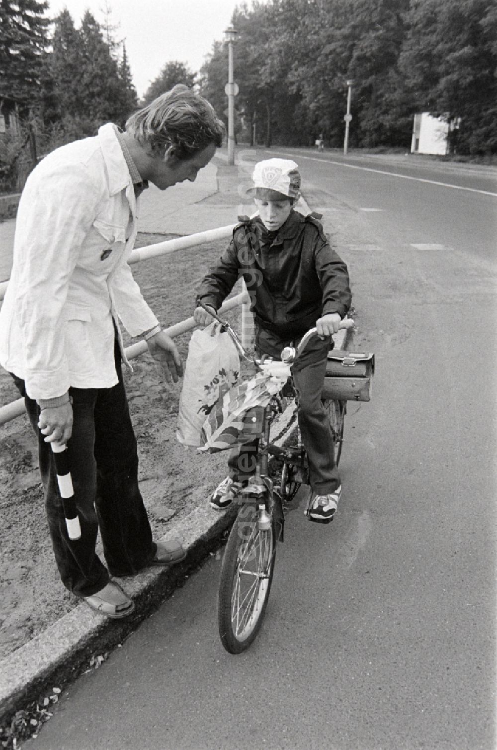 GDR image archive: Berlin - Volunteer traffic assistant of the People's Police checking the road safety of a cyclist in traffic at the intersection at Schulzendorfer Strasse and Waltersdorfer Strasse in the Bohnsdorf district of Berlin, East Berlin in the territory of the former GDR, German Democratic Republic