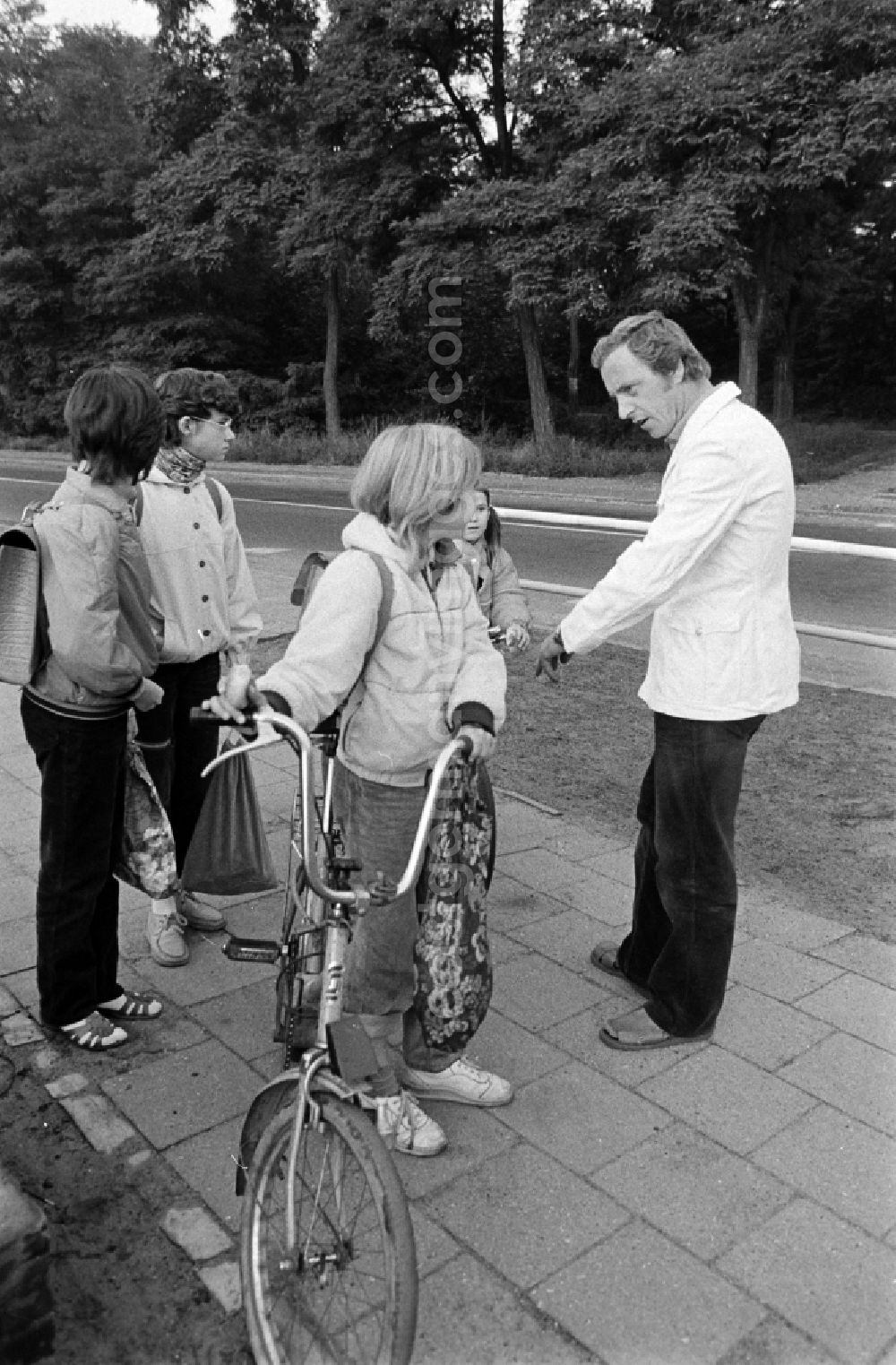 GDR photo archive: Berlin - Volunteer traffic assistant of the People's Police checking the road safety of a cyclist in traffic at the intersection at Schulzendorfer Strasse and Waltersdorfer Strasse in the Bohnsdorf district of Berlin, East Berlin in the territory of the former GDR, German Democratic Republic