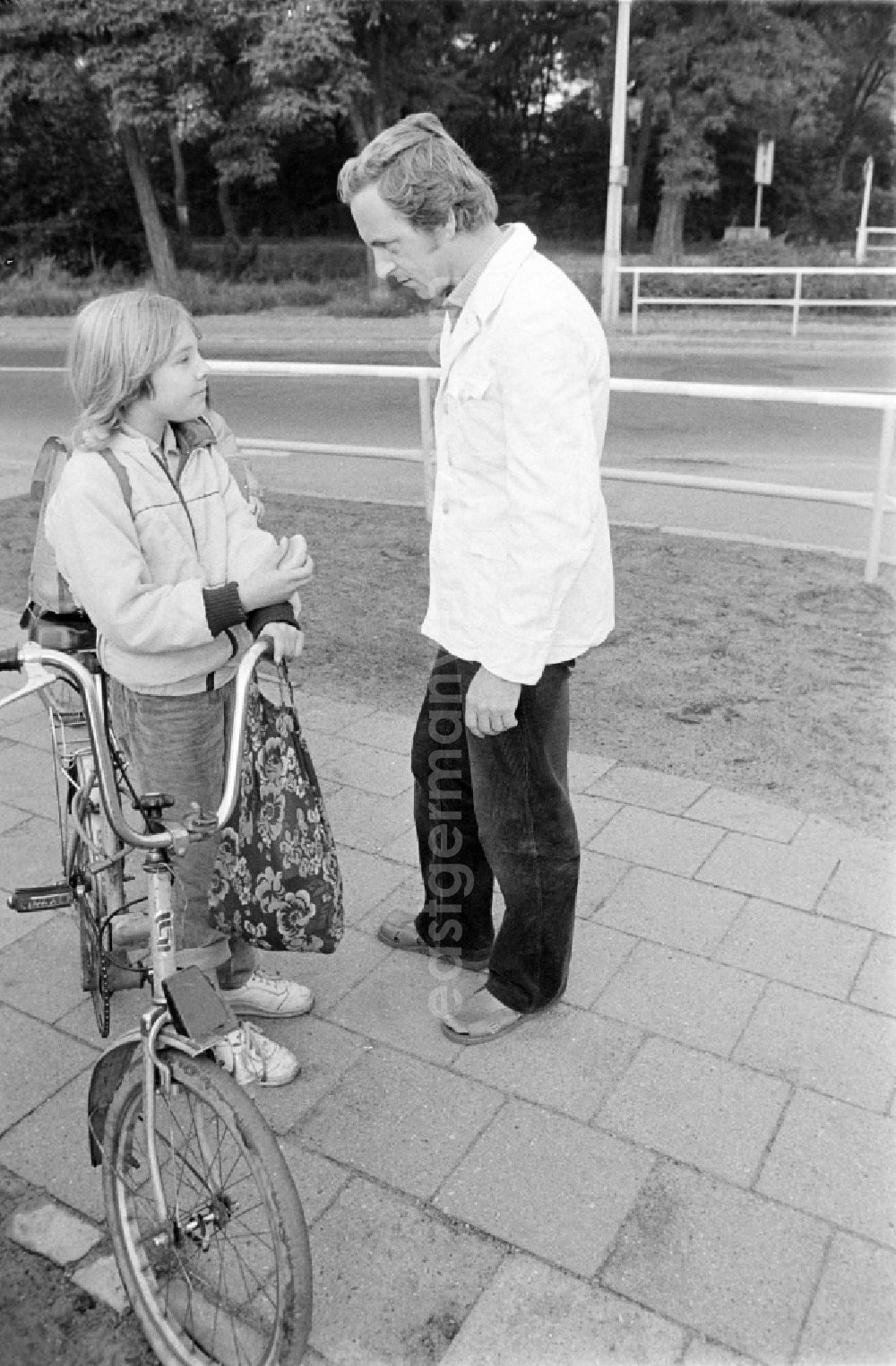 GDR picture archive: Berlin - Volunteer traffic assistant of the People's Police checking the road safety of a cyclist in traffic at the intersection at Schulzendorfer Strasse and Waltersdorfer Strasse in the Bohnsdorf district of Berlin, East Berlin in the territory of the former GDR, German Democratic Republic