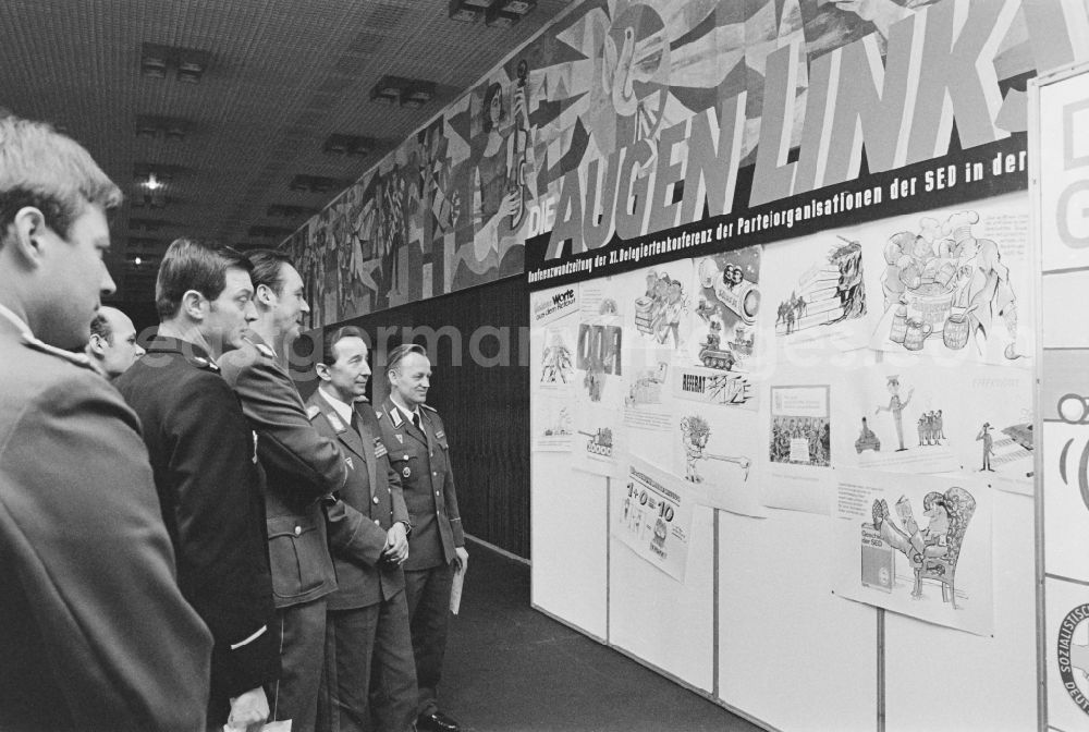 Dresden: Soldiers, non-commissioned officers, officers and generals as members of the NVA National Peoples Army viewing the conference wall newspaper Augenlink at the XI. Delegates Conference in the Kulturpalast in the Altstadt district of Dresden, Saxony in the territory of the former GDR, German Democratic Republic