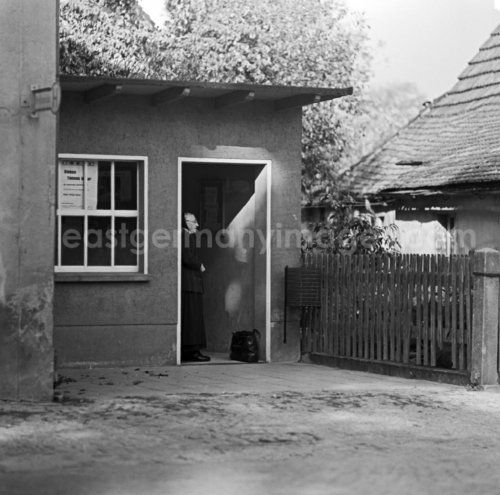 Räckelwitz: Elderly Sorbian farmers wife in everyday costume in the bus shelter on the main road in Raeckelwitz, Saxony in the area of the former GDR, German Democratic Republic