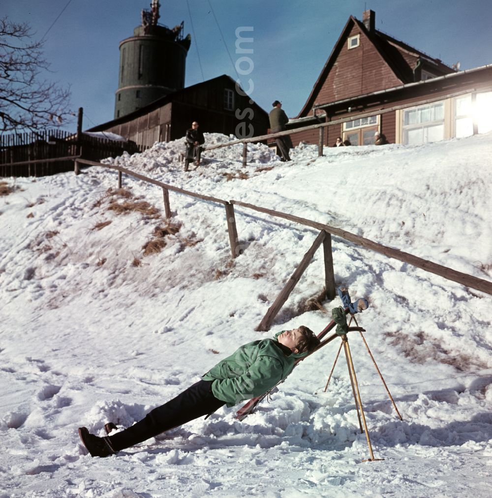 GDR image archive: Bad Tabarz - Sunbathing on skis on the Grosser Inselsberg with transmission tower in winter in Bad Tabarz, Thuringia in the territory of the former GDR, German Democratic Republic