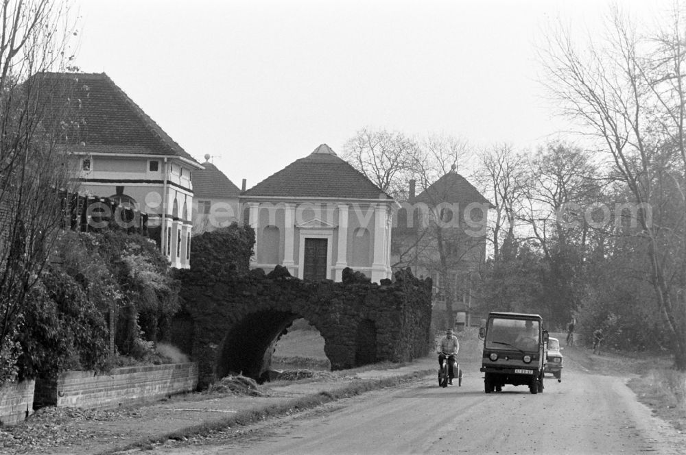 GDR picture archive: Oranienbaum-Wörlitz - Woerlitz Park in Oranienbaum-Woerlitz, Saxony-Anhalt in the area of the former GDR, German Democratic Republic. Multicar drives on the road past the Eisenhart bridge structure with the library pavilion and South Sea pavilion