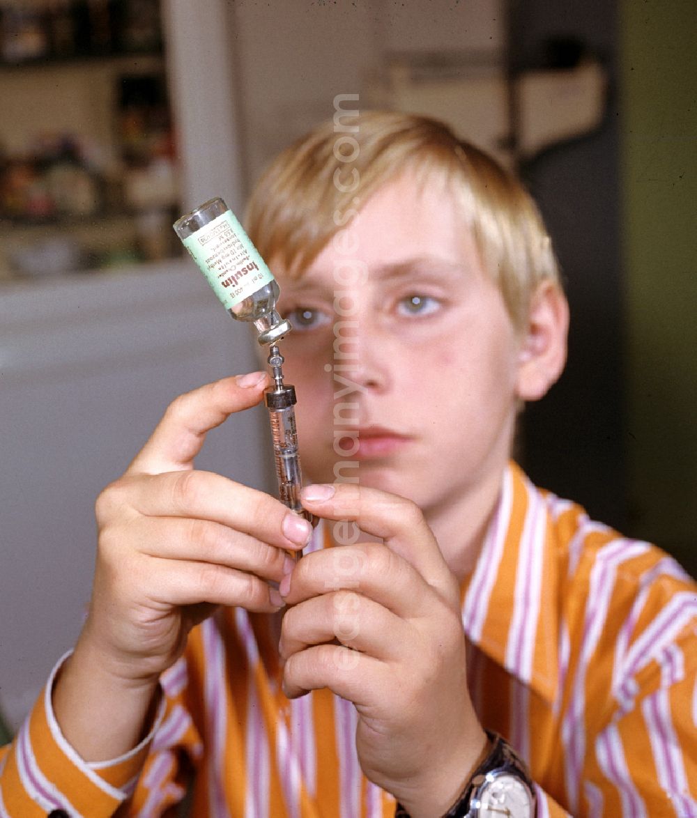 GDR photo archive: Karlsburg - A boy prepares his insulin injection at the Central Institute for Diabetes Gerhardt Katsch in Karlsburg, Mecklenburg-Vorpommern in the territory of the former GDR, German Democratic Republic