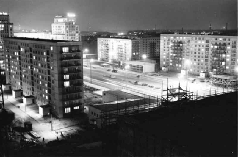 Blick auf die Karl-Marx-Allee bei Nacht. Mit Baustelle im Vordergrund.