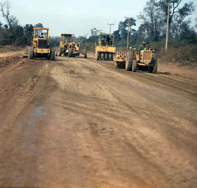 Einsatz von US-amerikanischen Baumaschinen für den Straßenbau in der Demokratischen Volksrepublik Laos.