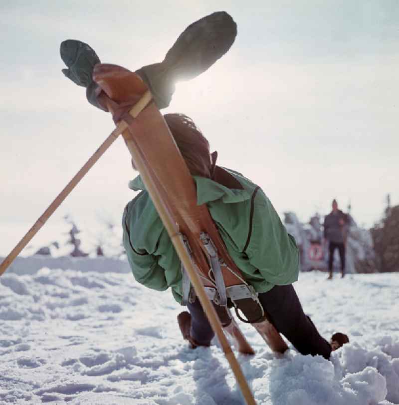 Sunbathing on skis on the Grosser Inselsberg with transmission tower in winter in Bad Tabarz, Thuringia in the territory of the former GDR, German Democratic Republic