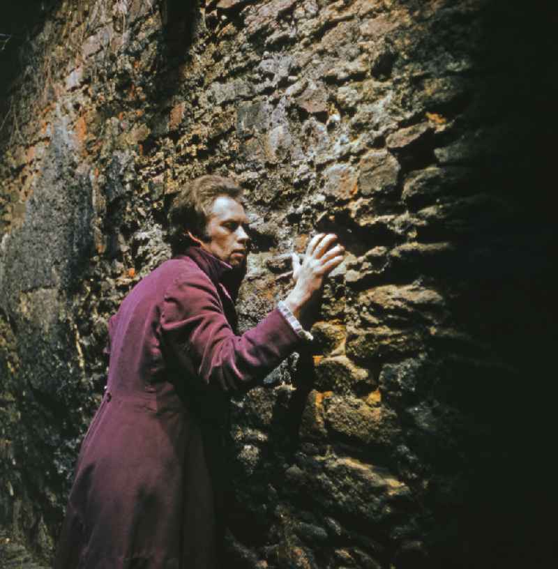 Scene from the film and television production 'Continent of Hope' in Bautzen, Saxony in the area of the former GDR, German Democratic Republic. The actor Manfred Schulz as the painter Wehle on a wall facade of the historic city wall