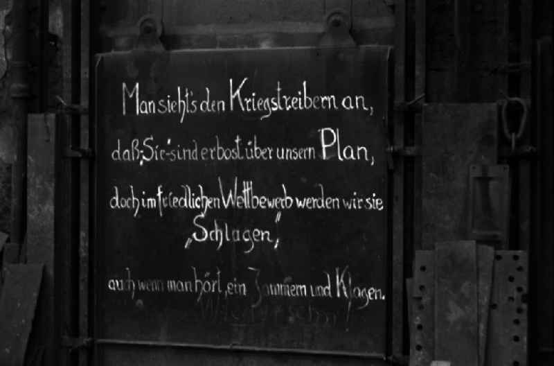 The inscription 'You can see it in the warmongers, that 'they' are angry about our plan, but in peaceful competition we will 'beat' them, even if you hear moaning and complaining.' hangs in the workshop of the Association of People's Owned Locomotive and Wagon Construction Companies (VVB LOWA) in Bautzen, Saxony in the area of the former GDR, German Democratic Republic