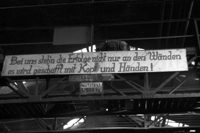 The slogan 'With us, successes are not just written on the walls, we achieve them with our heads and our hands!' hangs in the workshop of the Association of People’s Owned Locomotive and Wagon Construction Enterprises (VVB LOWA) in Bautzen, Saxony in the territory of the former GDR, German Democratic Republic