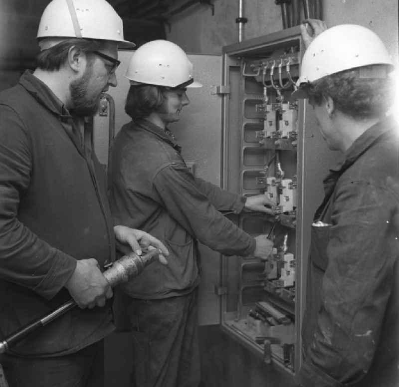 Arbeiten im Salvador-Allende-Viertel 1 / Amtsfeld. Im Bild: Drei Elektriker / Starkstromtechniker bei letzten Handgriffen an einem Sicherungskasten. Baubeginn im Allende- Viertel Köpenick war 1971. In den achtziger Jahren hatte die Neubausiedlung mit ihren 680