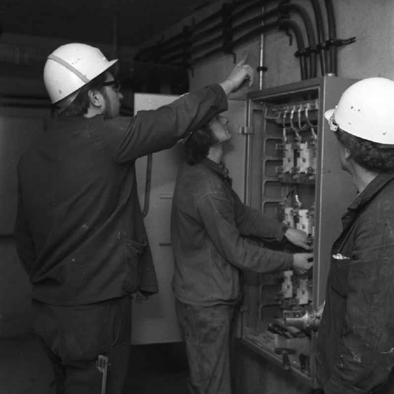 Arbeiten im Salvador-Allende-Viertel 1 / Amtsfeld. Im Bild: Drei Elektriker / Starkstromtechniker bei letzten Handgriffen an einem Sicherungskasten. Baubeginn im Allende- Viertel Köpenick war 1971. In den achtziger Jahren hatte die Neubausiedlung mit ihren 680