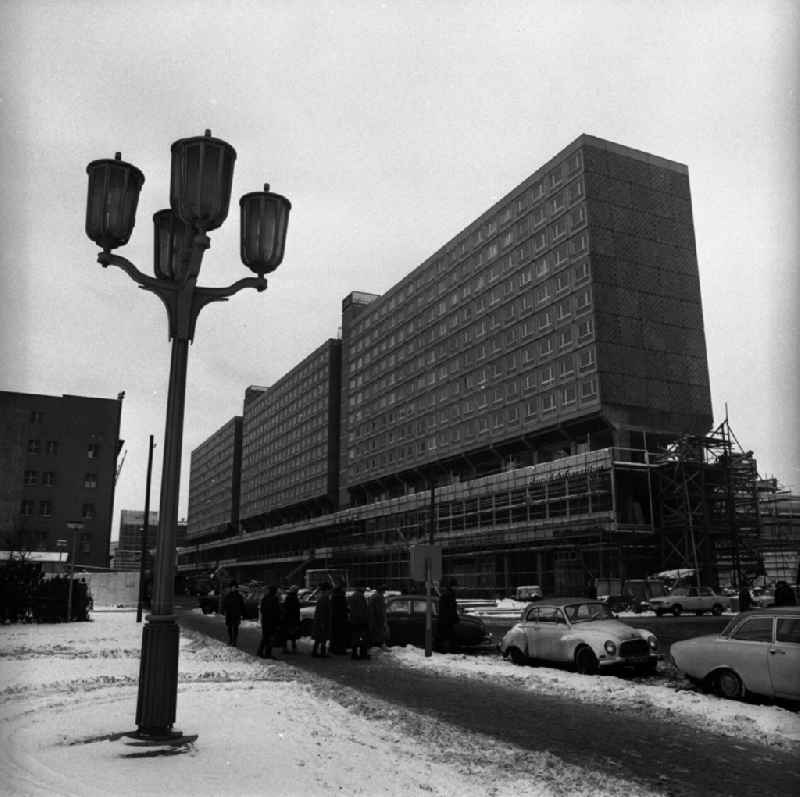 Die Baustelle Rathausstraße / Karl-Liebknecht-Straße. Das Stelzenhaus / Wohnhaus / Wohnblock in der Rathausstraße kurz vor der Fertigstellung. Straßenlaterne im Vordergrund. Autos parken auf Straße. Menschengruppe auf Gehweg.