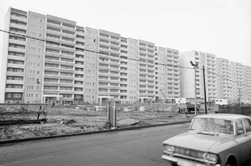 Blick auf das neu gebaute Arbeiterwohnheim an der Rhinstraße / Ecke Landsberger Allee, dem heutigen COMFORT Hotel. Davor Baustelle der Außenanlagen sowie Auto vom Typ Moskwitsch 412 auf Strass.