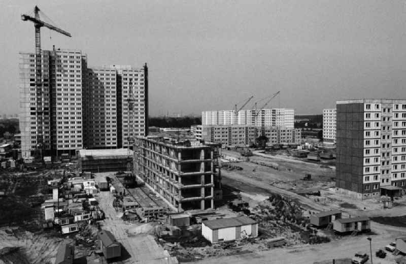 Bauarbeiten im künftigen Wohnbezirk Friedrichsfelde-Ost in Berlin. Bauwagen und Kräne stehen am Rohbau. Der Stadtteil wird geprägt von vielgeschossigen Neubauten und liegt zwischen der S-Bahntrasse Richtung Strausberg im Norden und dem Gelände des Tierpark im Süden. Durch das Wohngebiet zieht sich die Bundestraße B1/B5.