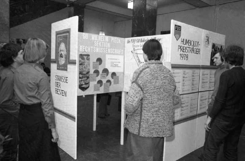 Besucher stehen vor Exponaten in einer Ausstellung im Foyer der Humboldt Universität.