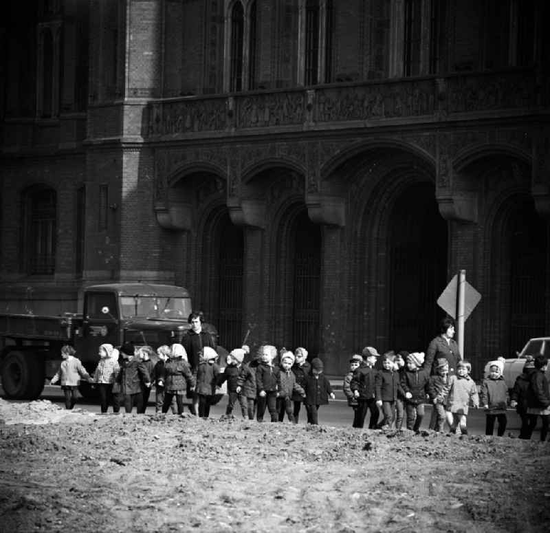 Kinder eines Kindergarten machen einen Spaziergang / Ausflug vorbei am Sitz des Berliner Magistrat (heute Senat), das Rote Rathaus. Im Hintergrund fährt ein LKW auf der Strasse.