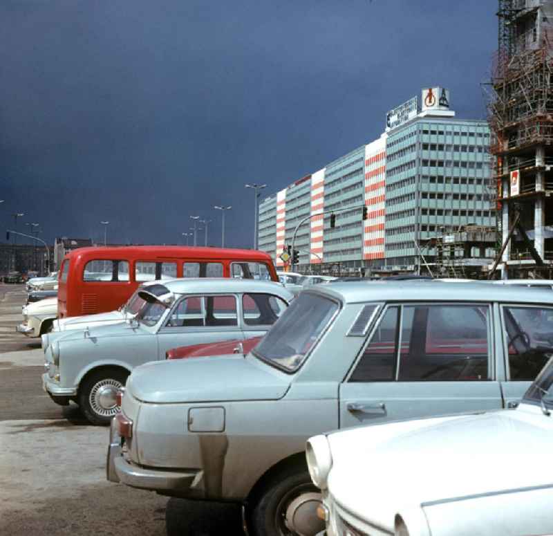 Autos parken im Mittelstreifen der Karl-Marx-Allee in Berlin Mitte, im Hintergrund das neu errichtete Haus der Elektroindustrie. Gebäude wie diese und eine großflächige Umgestaltung des Alex sollten Ost-Berlin als Hauptstadt der DDR das Antlitz einer sozialistischen Großstadt verleihen.