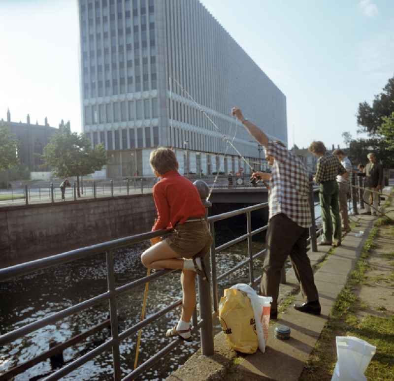 Auch das gehört zum Berliner Stadtbild - bei Alt und Jung beliebt war das Angeln in der Spree, hier am Ministerium für Auswärtige Angelegenheiten (MfAA) in Berlin-Mitte, im Hintergrund die Ruine der Friedrichswerderschen Kirche. Das Gebäude des Außenministeriums wurde 1996 abgerissen und durch den Wiederaufbau der Alten Kommandantur ersetzt.