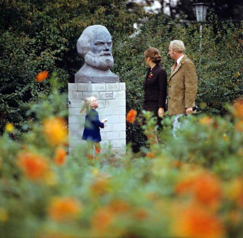 Eine Familie geht bei ihrem Spaziergang an einer Karl-Marx-Büste des Künstlers Hans Kies vorbei.