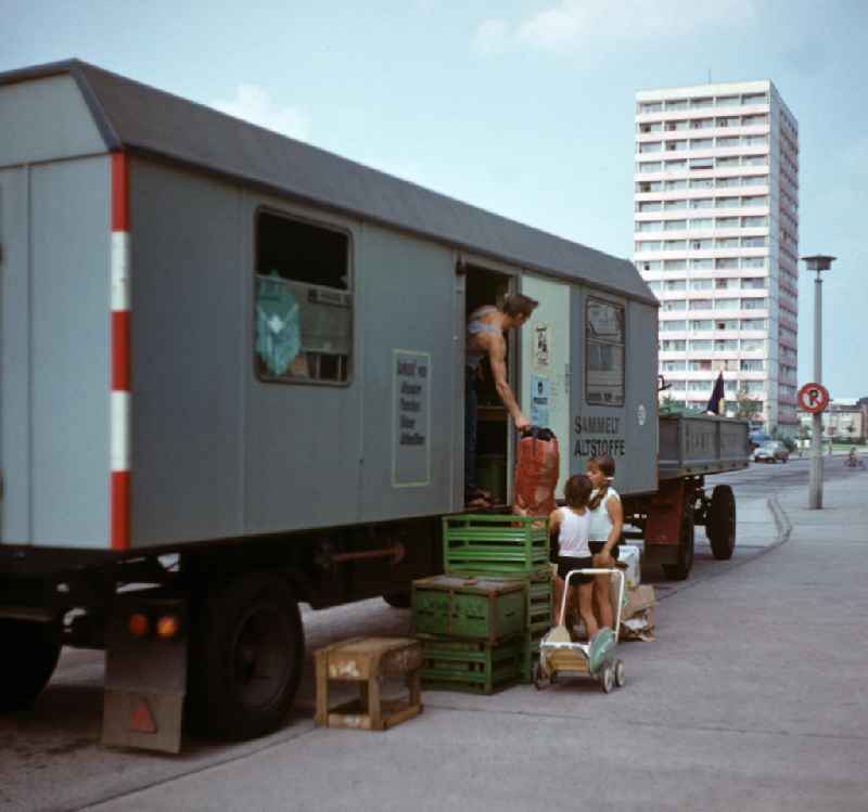 Zwei Kinder bringen mit einem alten Kinderwagen Altstoffe zu einem als SERO-Annahmestelle fungierenden Bauwagen in der Andreasstraße in Berlin-Friedrichshain. Die Rücknahme der sogenannten Sekundärrohstoffe in der DDR war durch ein dichtes System von Annahmestellen verschiedener Form gesichert. Die DDR-Wirtschaft war auf die Rückführung von Glas, Papier, Schrott und Textilien angewiesen. Und die Menschen erhielten ein kleines zusätzliches Haushaltsgeld.