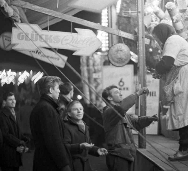 Junge Leute versuchen ihr Glück an einer Losbude auf dem Berliner Weihnachtsmarkt.