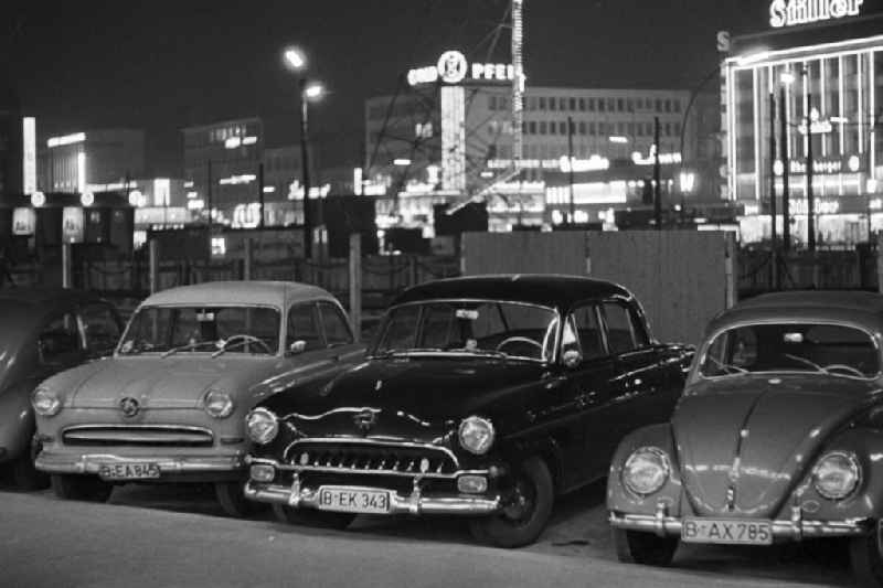 Autos parken am Rand des Kurfürstendamms in Westberlin. Im Hintergrund Leuchtreklame wohin das Auge blickt - als Schaufenster des Westens und Symbol des Wirtschaftswunders erstrahlte der Kurfürstendamm, Westberlins wichtigste Flaniermeile, auch abends in hellem Licht. In den 5